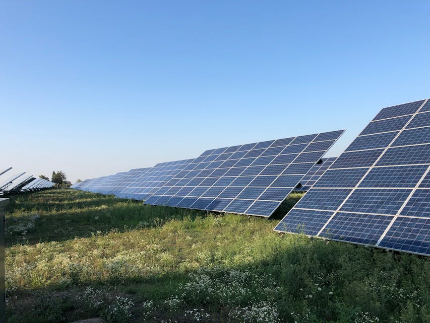 pexels photo 16586163 16586163 Solar panels in a green field under a clear blue sky in Tortona, Italy.